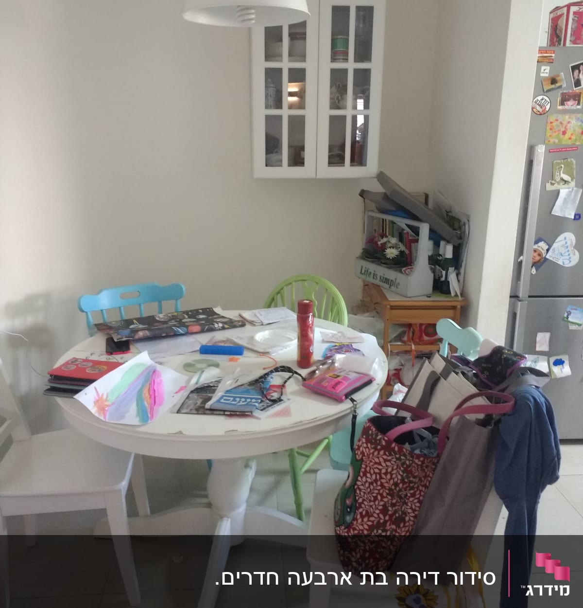 שולחן עגול עם חפצים, תיקים ובגדים מפוזרים
